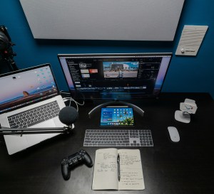 Desk with computer, keyboard, paper and pen
